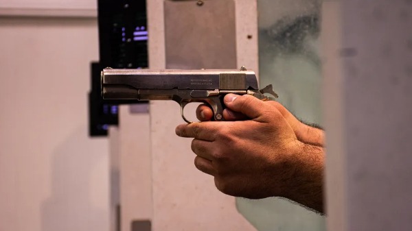 Homem segura arma em um clube de tiro  Foto: Unsplash/Hosein Charbaghi - Foto: Unsplash/Hosein Charbaghi